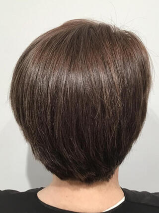Foto del dopo: donna vista da dietro con capelli castani corti senza capelli bianchi dopo il colore.