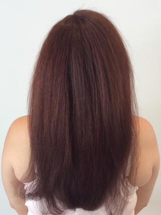 Foto del dopo: donna vista da dietro con lunghi capelli rossi sani dopo il colore.