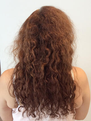 Foto del prima: donna vista da dietro con lunghi capelli rossi danneggiati prima del colore.