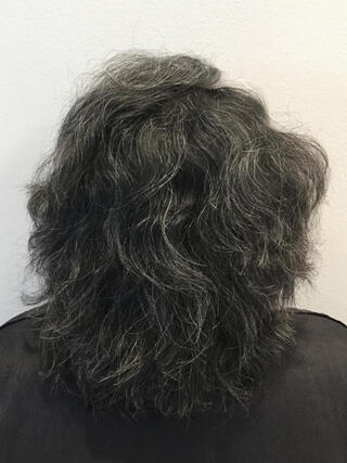 Foto del prima: donna vista da dietro con capelli neri corti con molti capelli bianchi prima del colore.